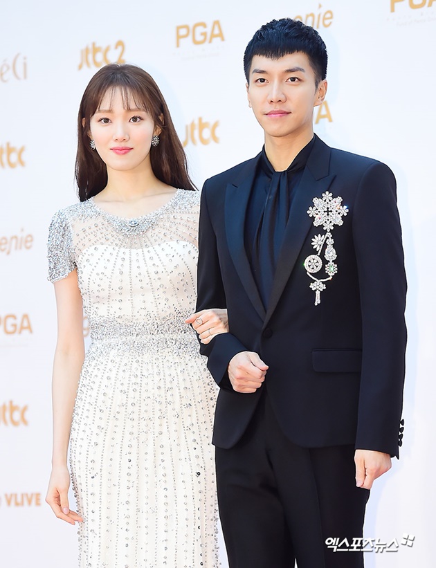 Gambar Foto Lee Sung Kyung dan Lee Seung Gi yang juga memandu acara datang bergandengan tangan di red carpet Golden Disc Awards 2018.
