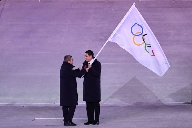 Gambar Foto Presiden Komite Olimpiade Thomas Bach menyerahkan bendera Olimpiade kepada Walikota Beijing Chen Jining.