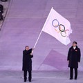 Presiden Komite Olimpiade Thomas Bach terlihat membawa bendera Olimpiade.
